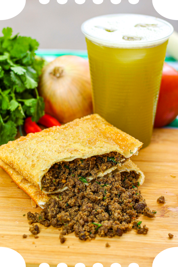 Pastel de carne aberto e copo de caldo de cana sobre a tábua